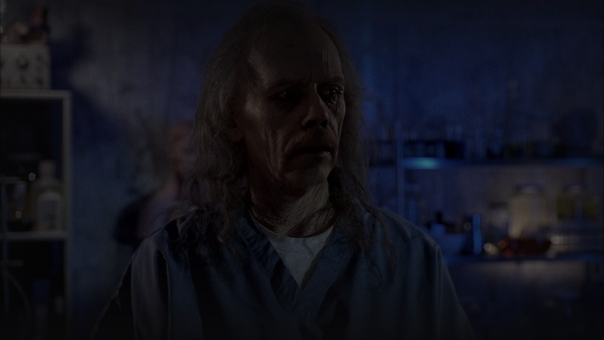 Still from Body Bags (1993) — letterboxd still from Body Bags (1993), checked against TMDB backdrops; baked through scripts/bake_dark_photo.py at factor 0.45, output brightness 20.3